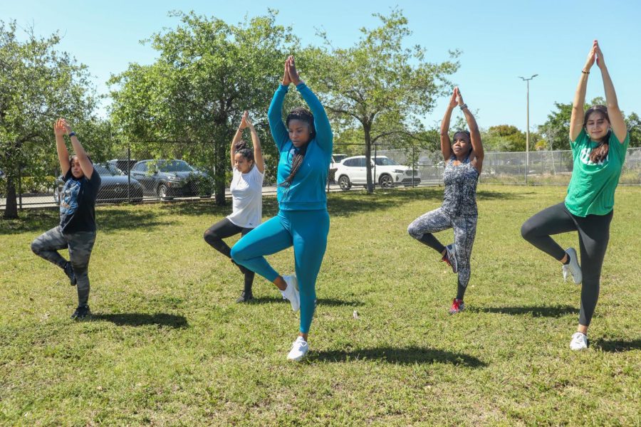 Participants perform the Tree Pose to warm up for the rest of their workout.