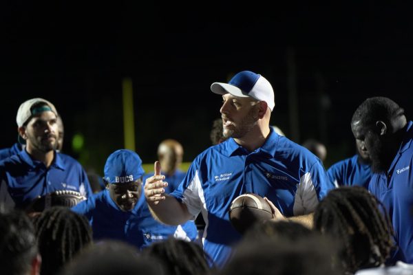 Principal Jonathan Britton addresses the varsity football team after their 14-7 victory over the Homestead Broncos